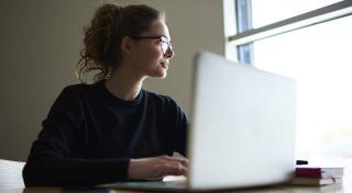 Woman at a computer looking out of a window