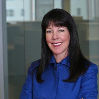 a woman in a blue shirt and smiling at the camera