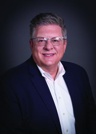 Richard M. Cohen wearing a suit and tie smiling at the camera