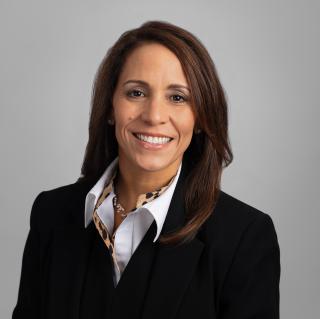 a person wearing a suit and tie smiling at the camera