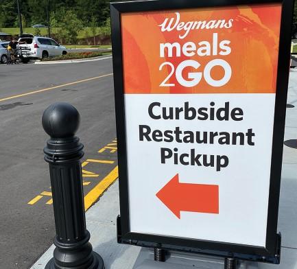 The Wegmans e-commerce operation offers several lanes for curbside pickup of hot meals such as pizza, a rack of ribs, or a batch of Indian curry with rice.