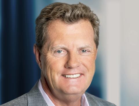 Frank Slootman wearing a suit and tie smiling and looking at the camera