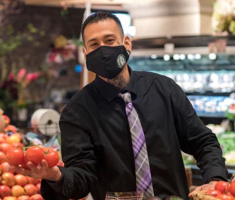 a person standing in front of a fruit stand