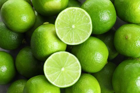 a pile of oranges sitting on top of a green apple