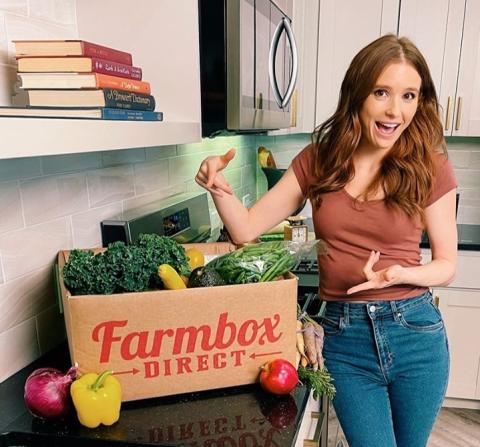 a woman standing in front of a fruit stand