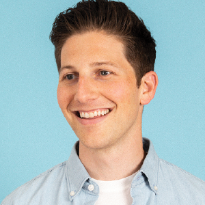 a man wearing a blue shirt and smiling at the camera