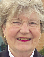 a person wearing a suit and tie smiling at the camera