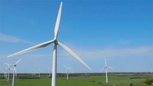 a windmill on top of a grass covered field