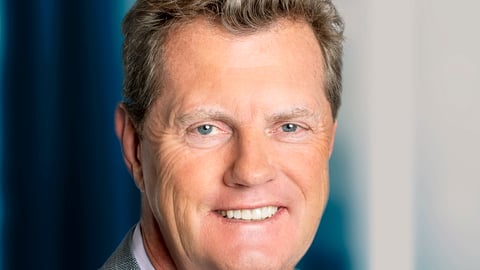 Frank Slootman wearing a suit and tie smiling and looking at the camera