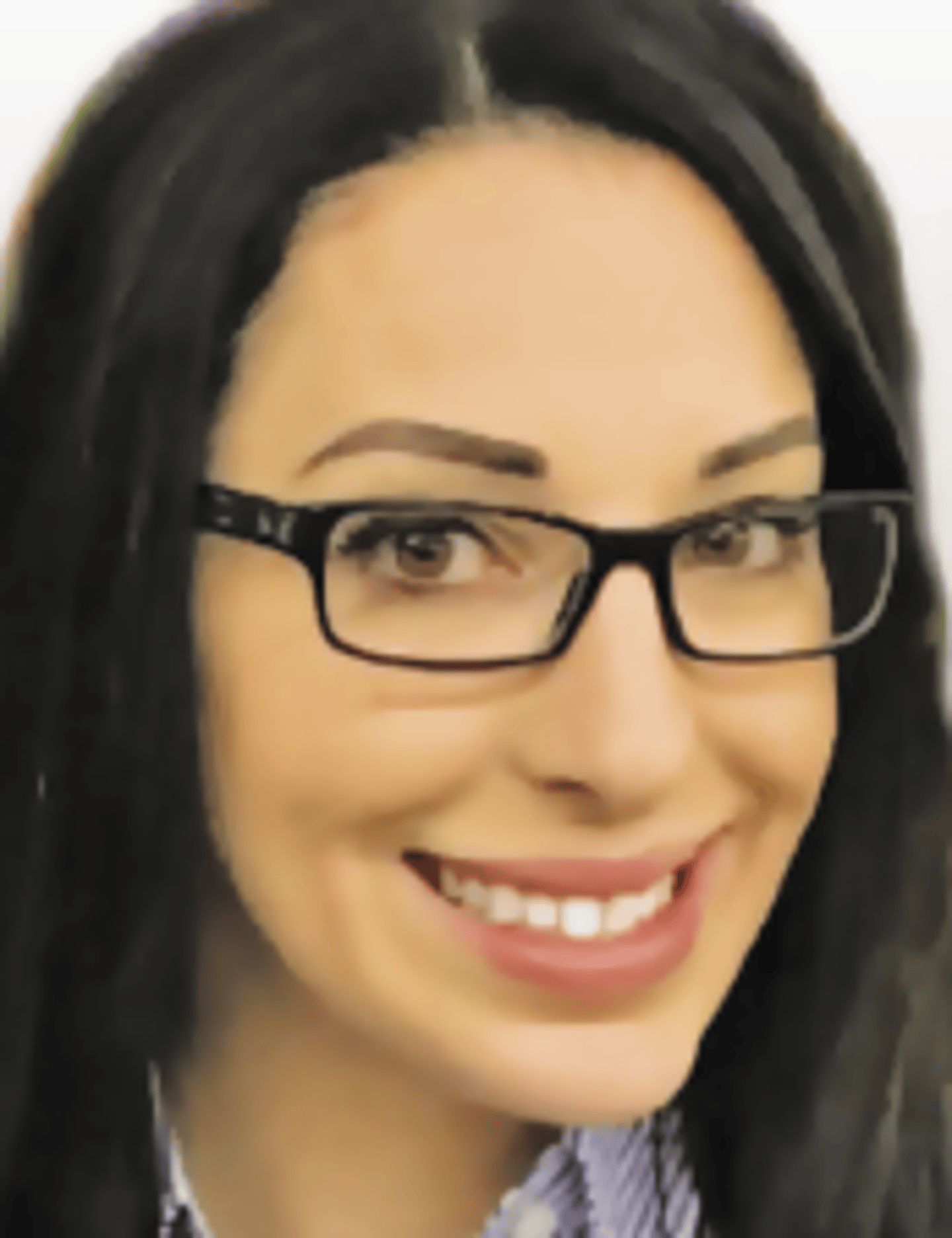 a woman wearing glasses and smiling at the camera