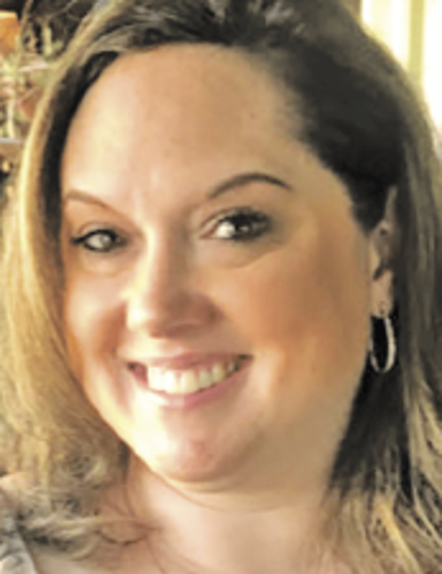 a close up of a woman who is smiling and looking at the camera