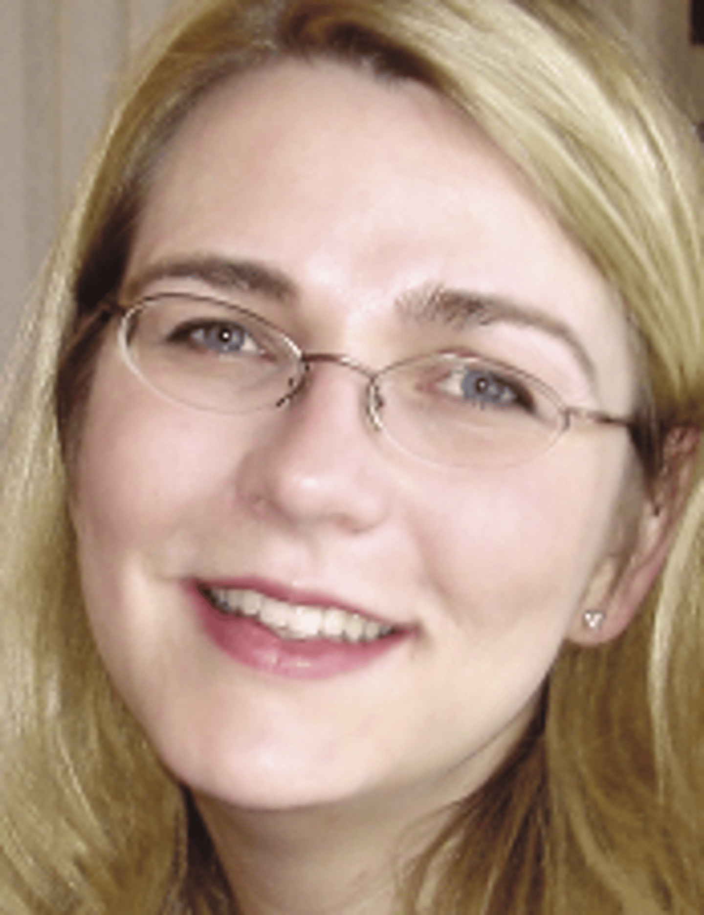 a close up of a woman wearing glasses and smiling at the camera