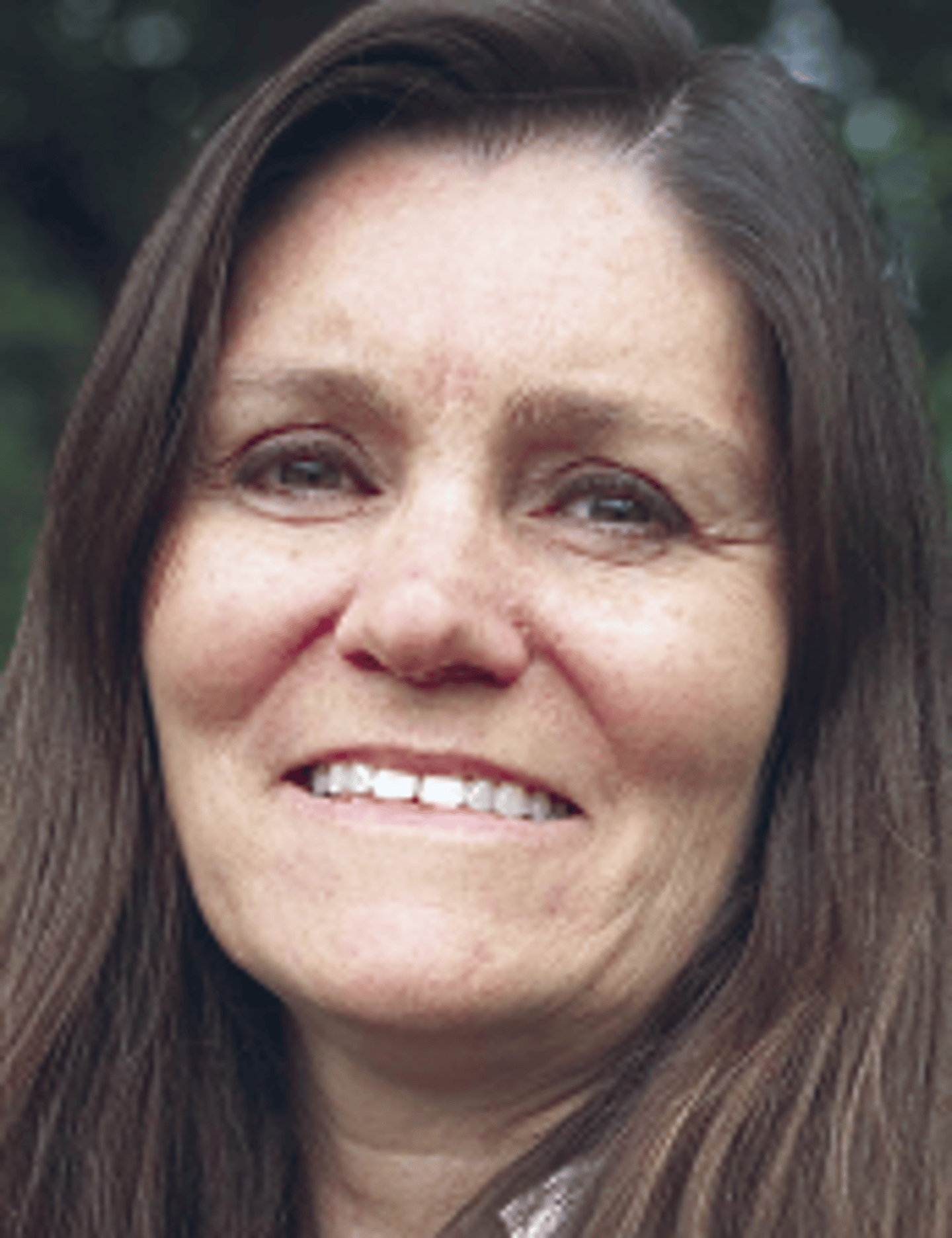 a close up of a woman who is smiling and looking at the camera