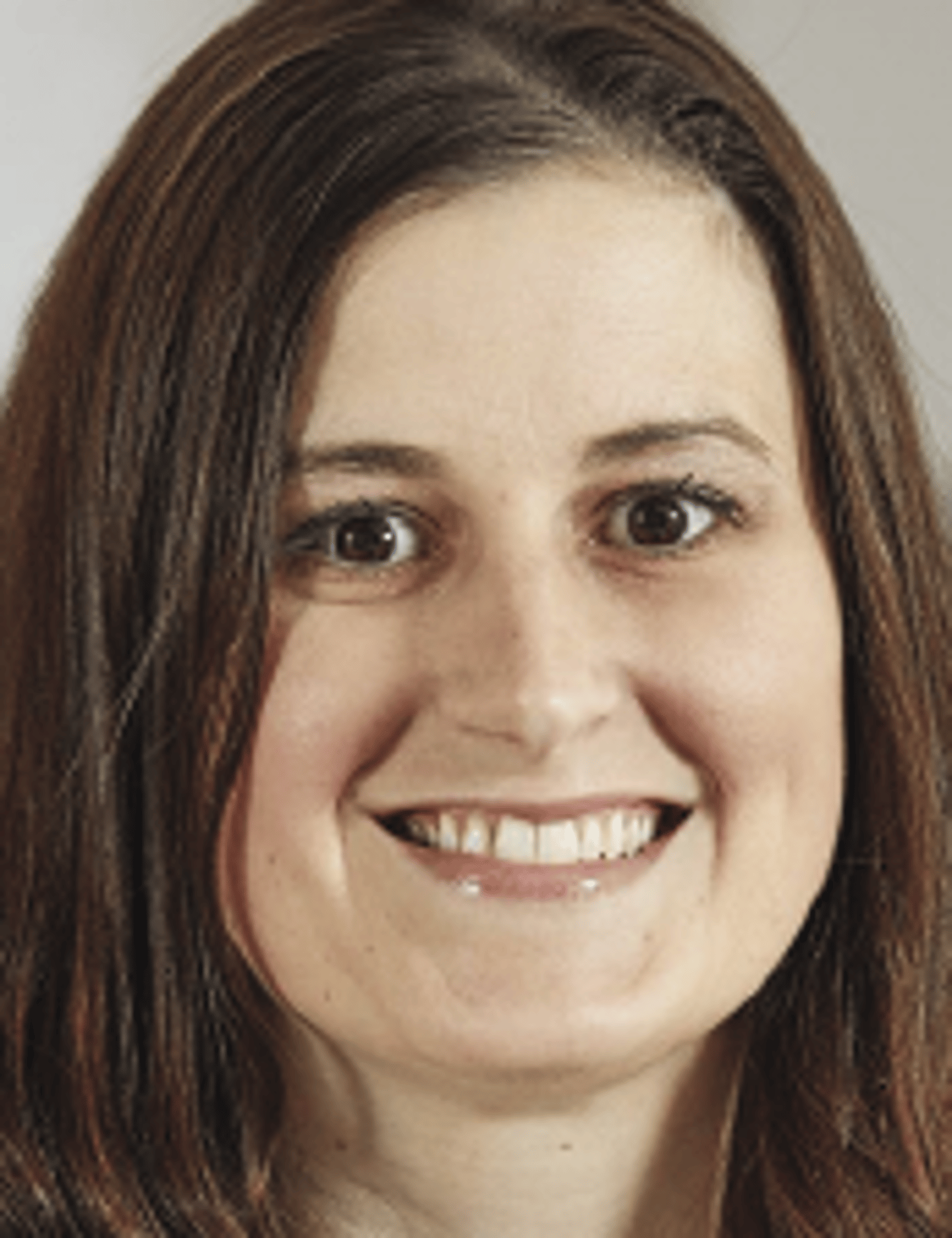 a close up of a woman who is smiling and looking at the camera