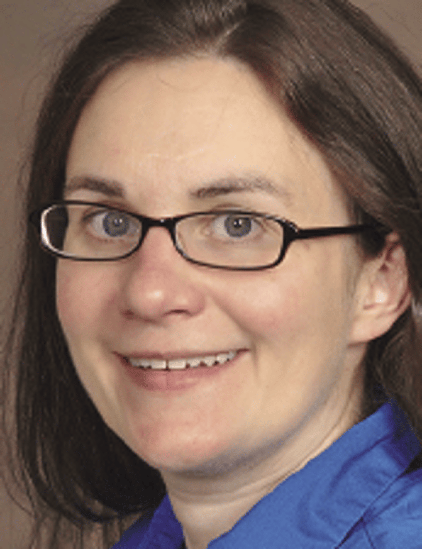 a close up of a woman wearing glasses and smiling at the camera