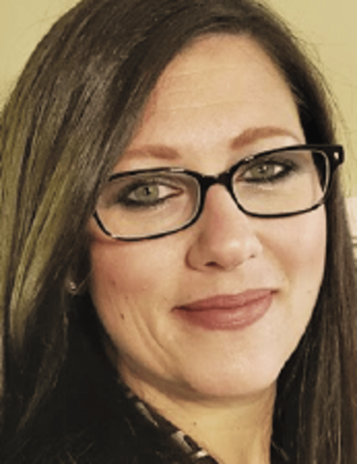 a close up of a woman in glasses looking at the camera