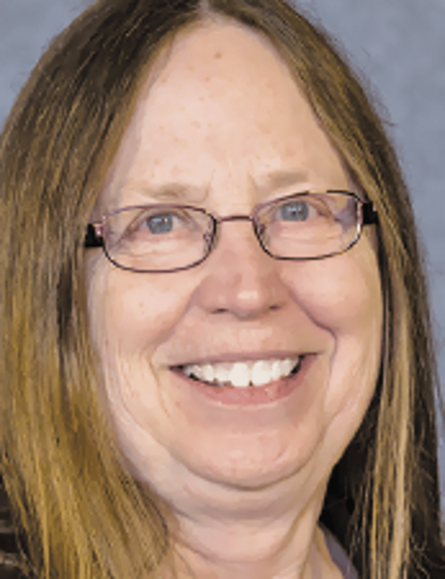 a close up of a woman wearing glasses and smiling at the camera