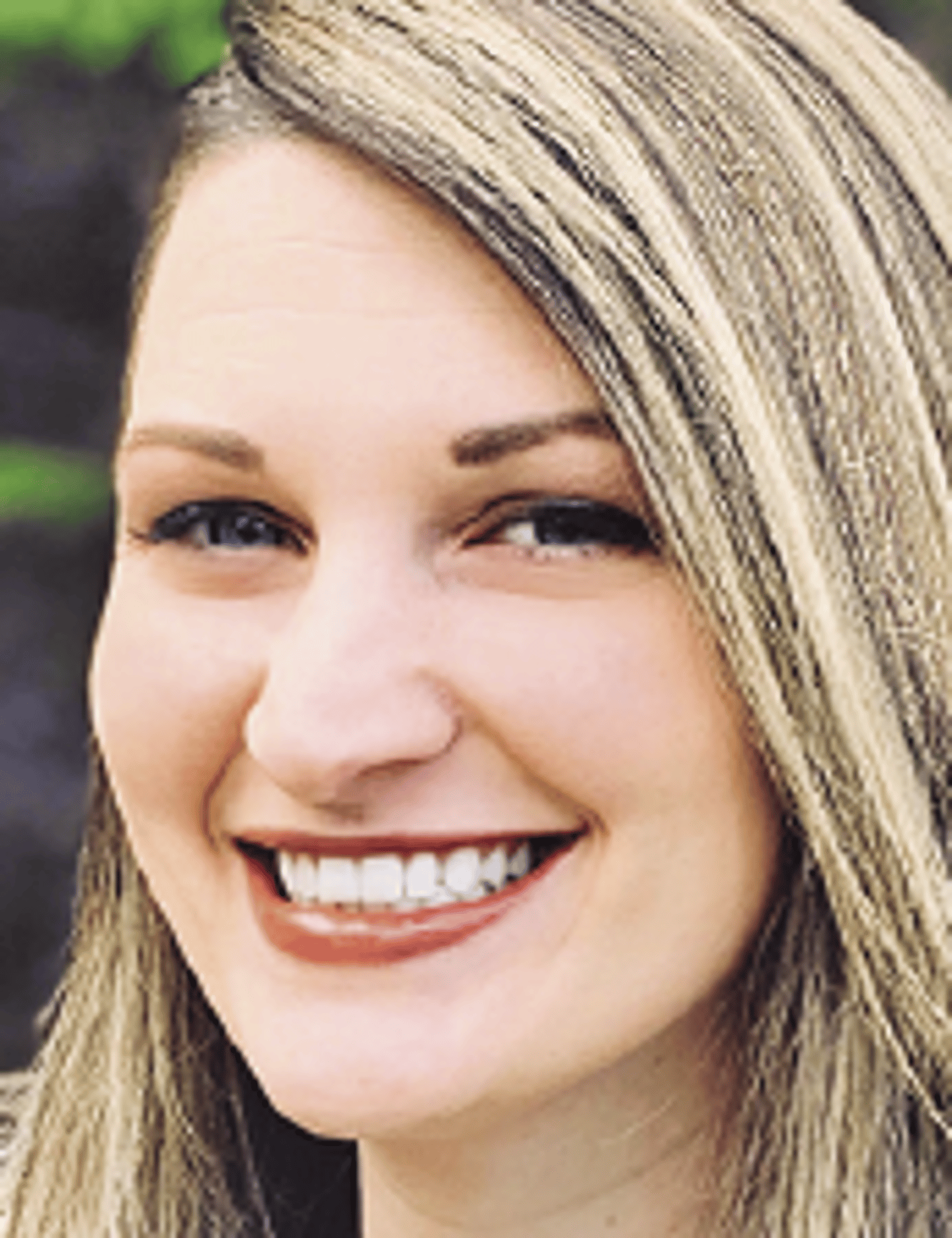 a close up of a woman wearing a hat and smiling at the camera