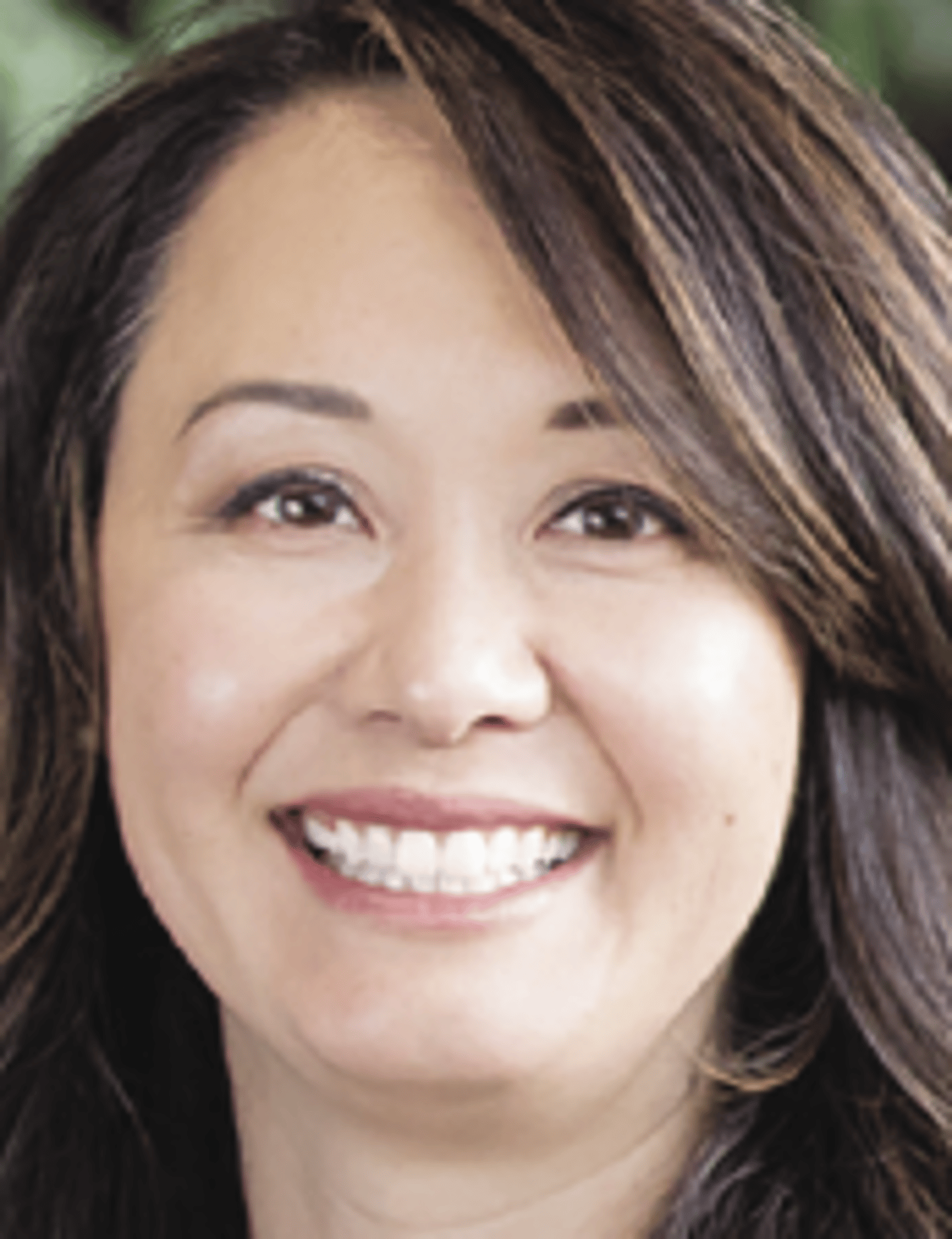 a close up of a woman who is smiling and looking at the camera