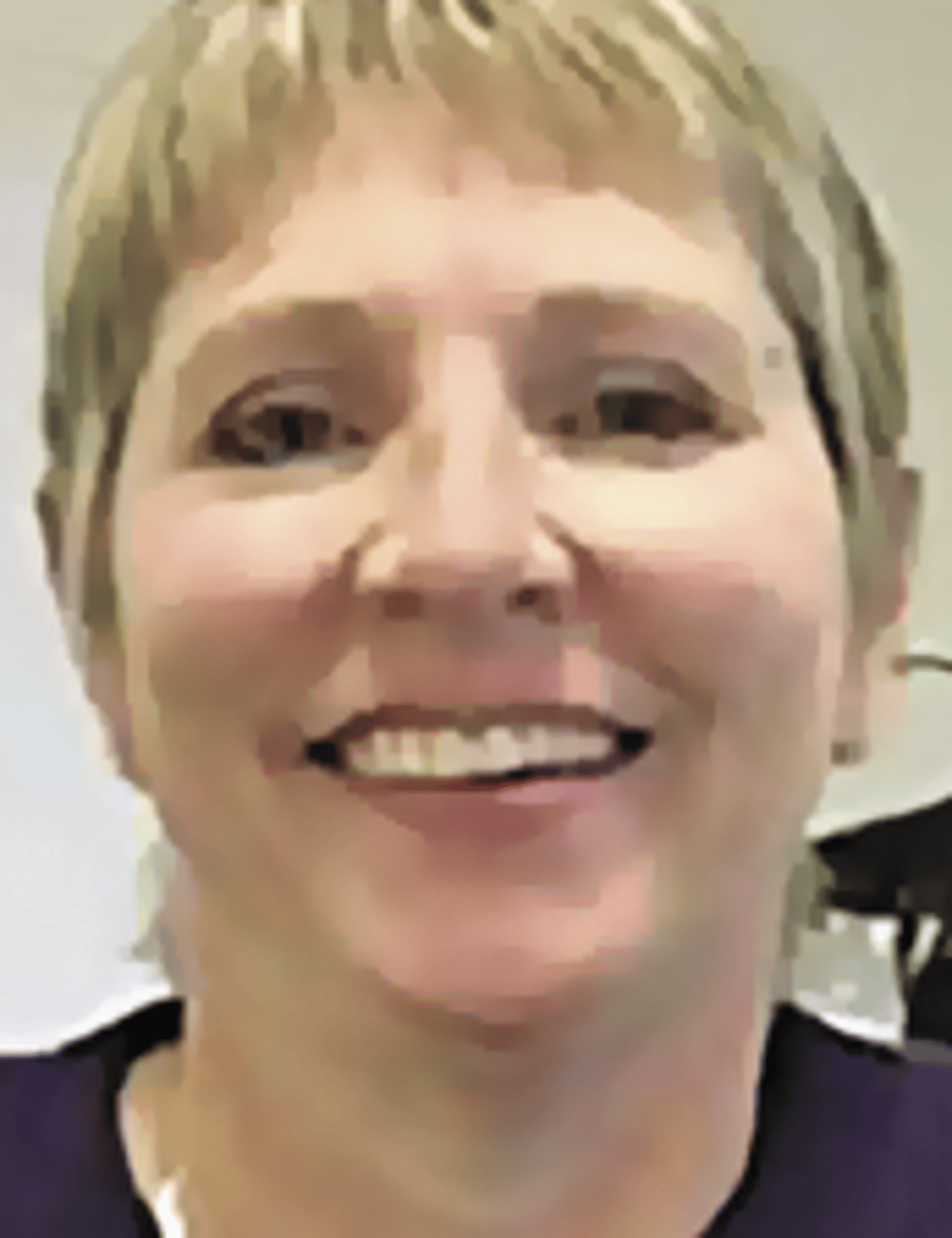 a close up of a woman wearing glasses and smiling at the camera