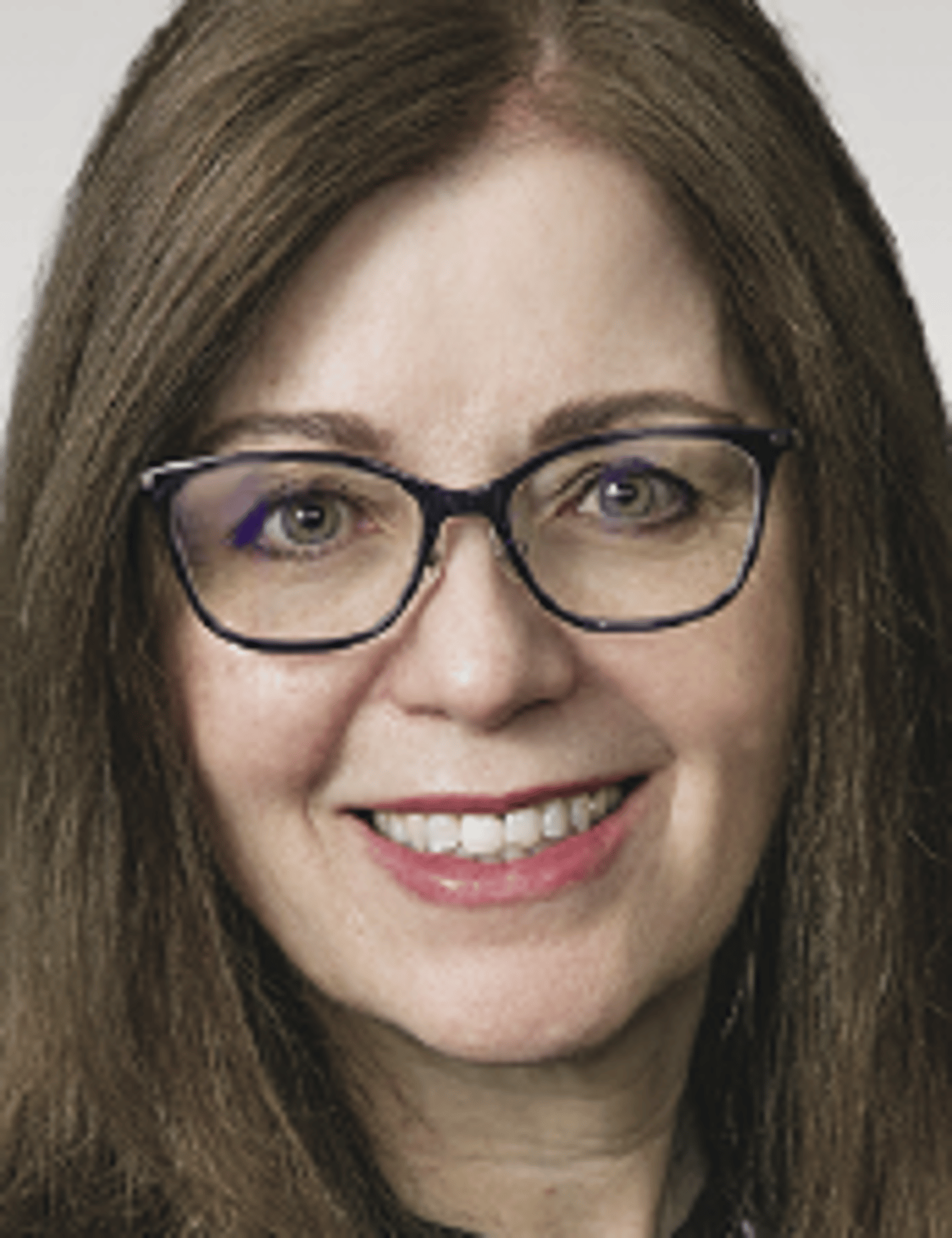 a close up of a woman wearing glasses and smiling at the camera