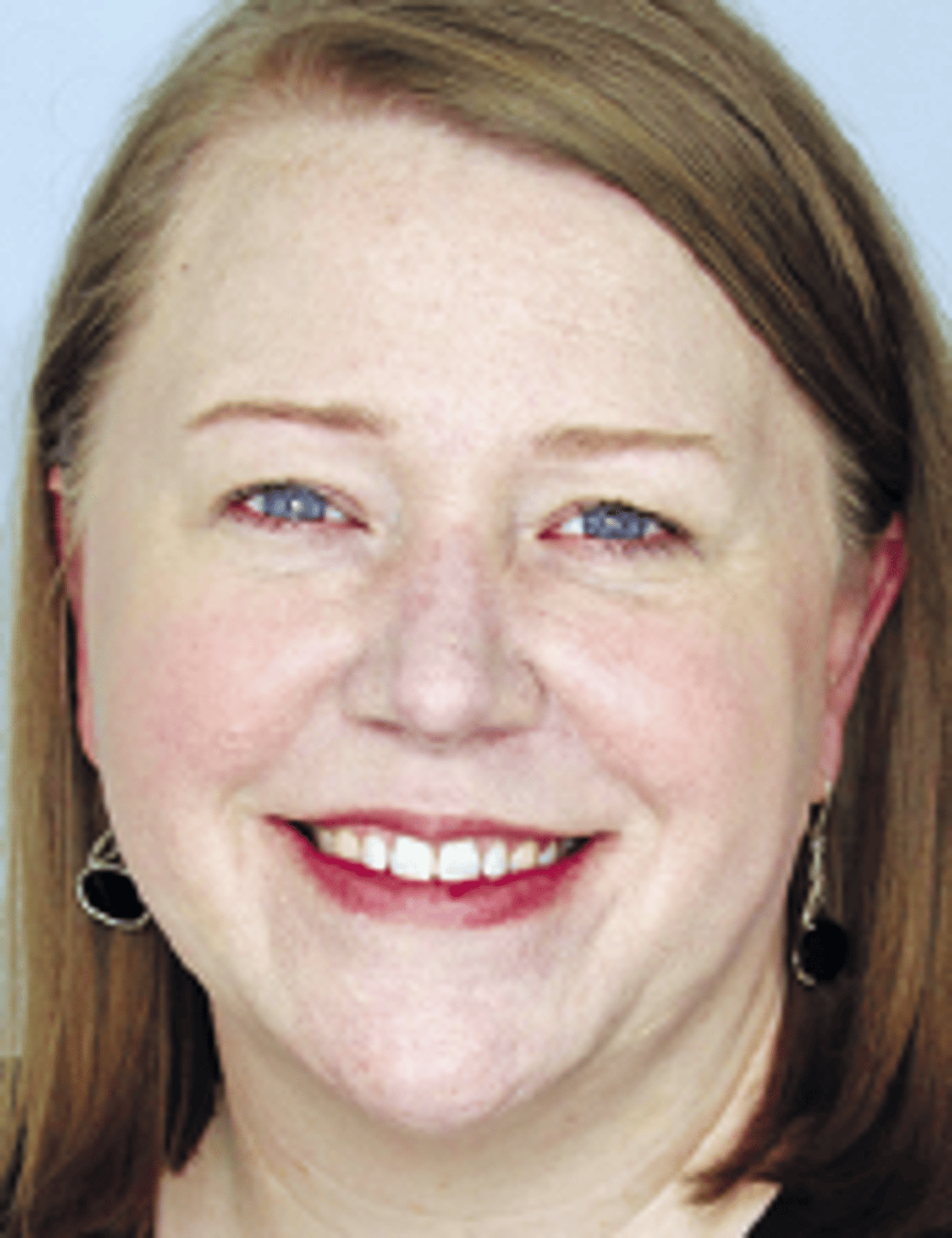 a close up of a woman who is smiling and looking at the camera