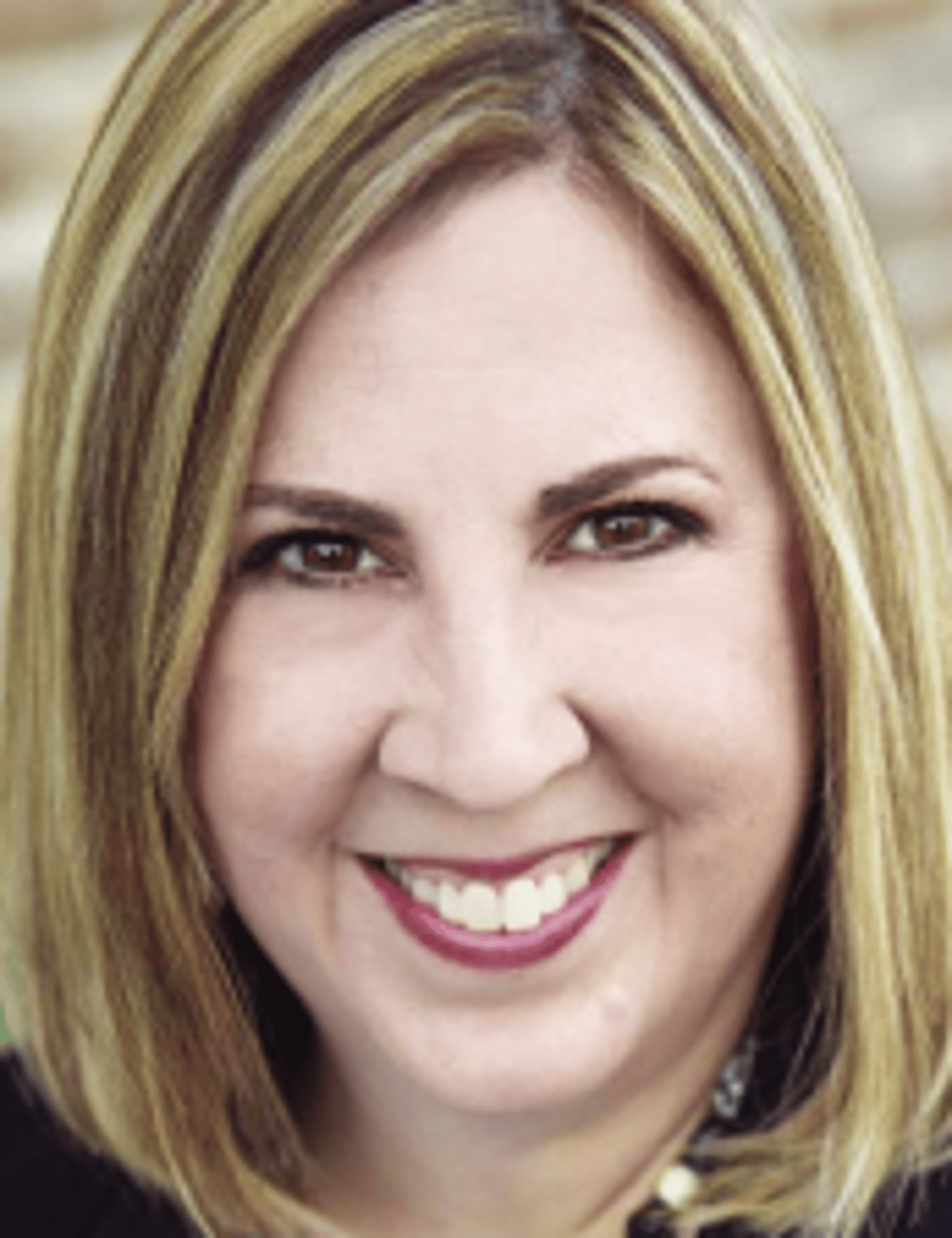 a close up of a woman who is smiling and looking at the camera