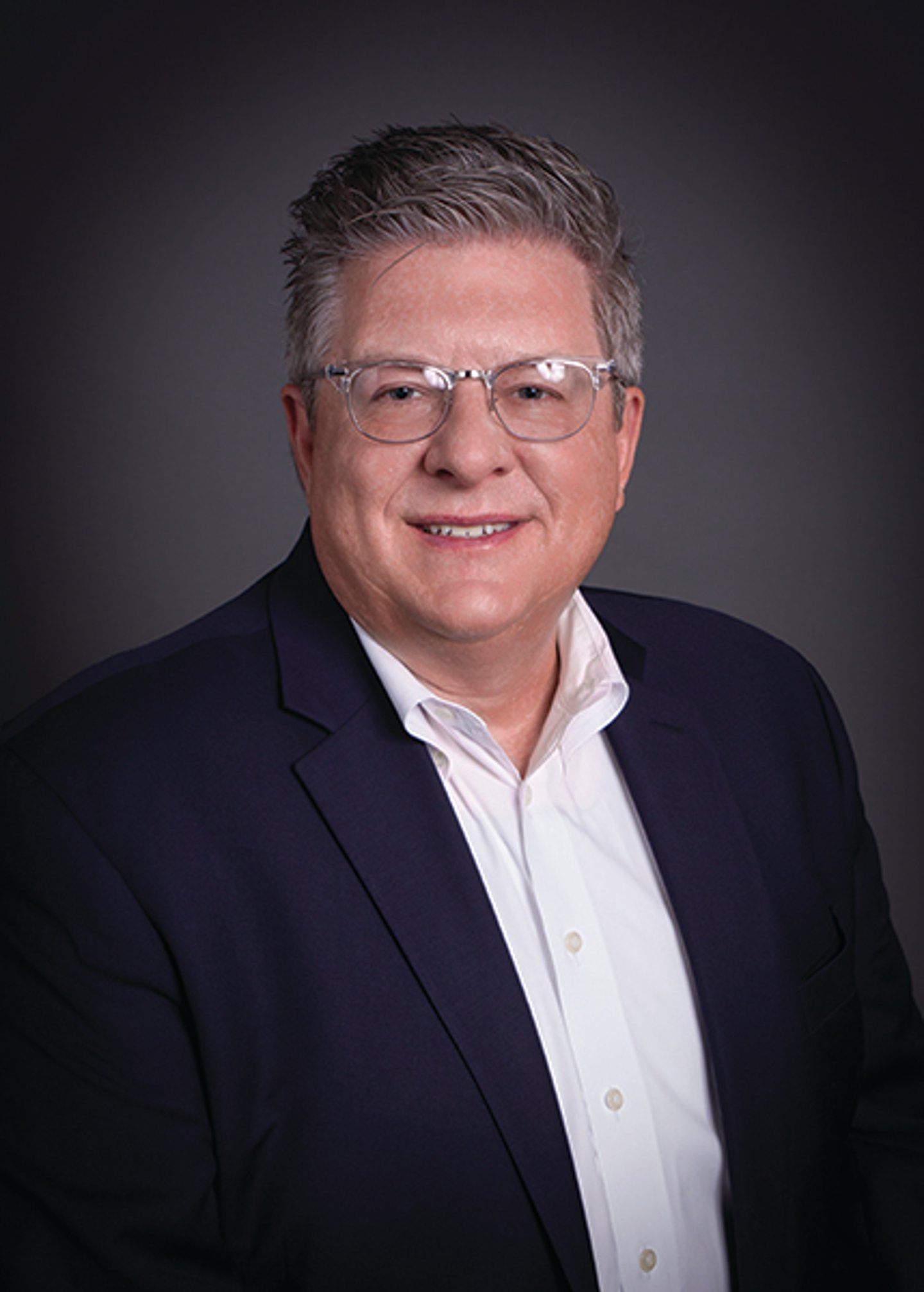 Richard M. Cohen wearing a suit and tie smiling at the camera