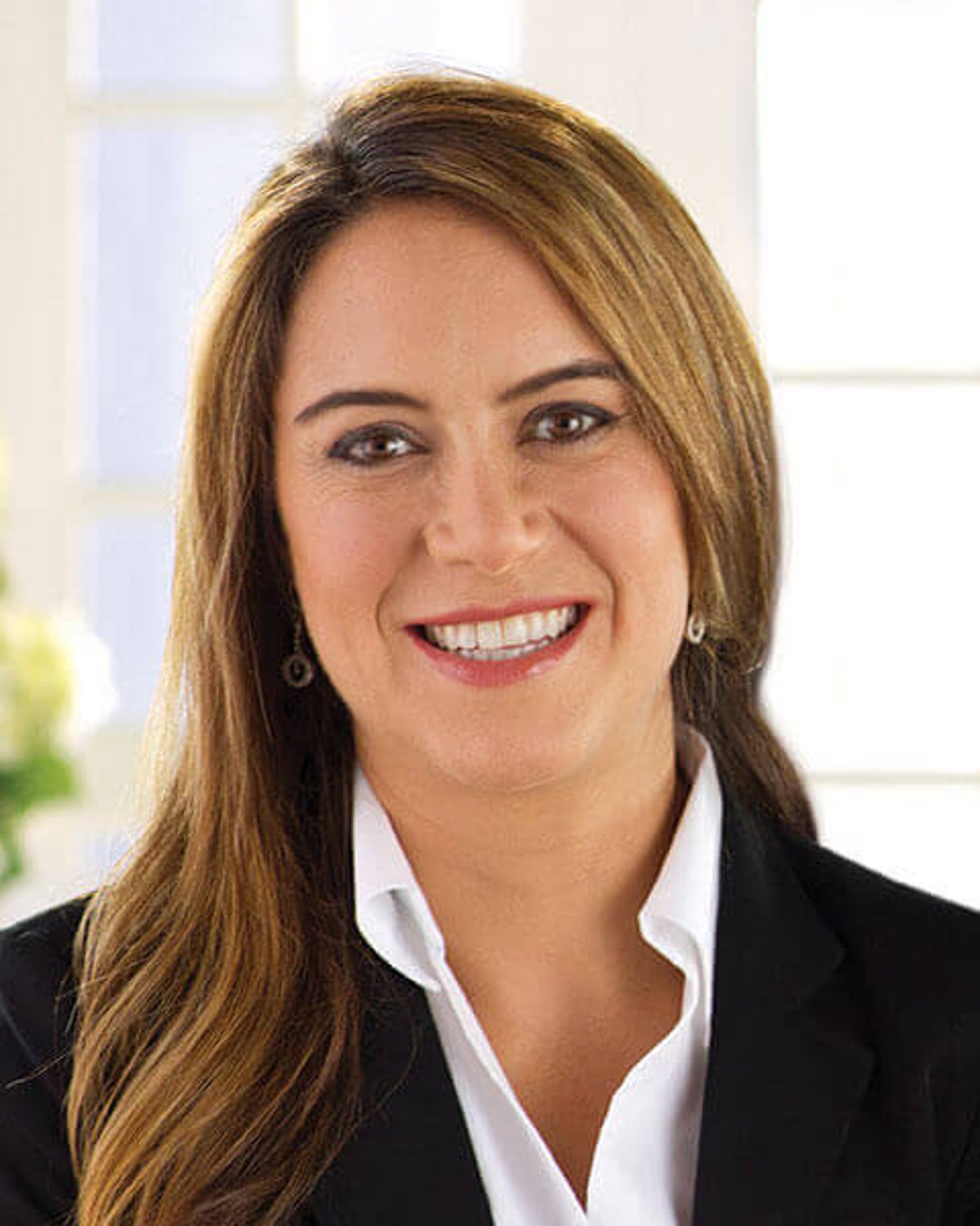 a woman wearing a suit and tie smiling at the camera