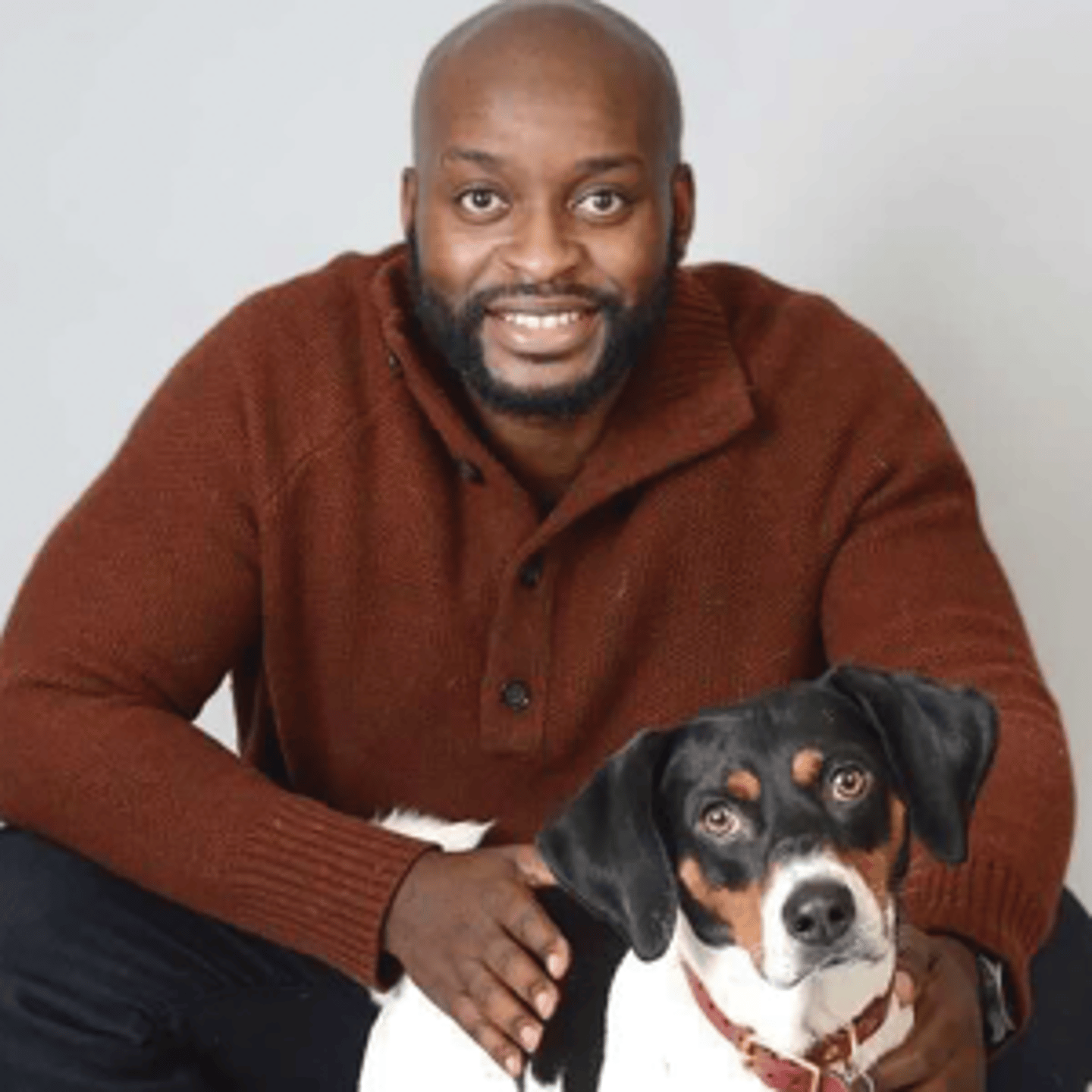 a man holding a dog posing for the camera