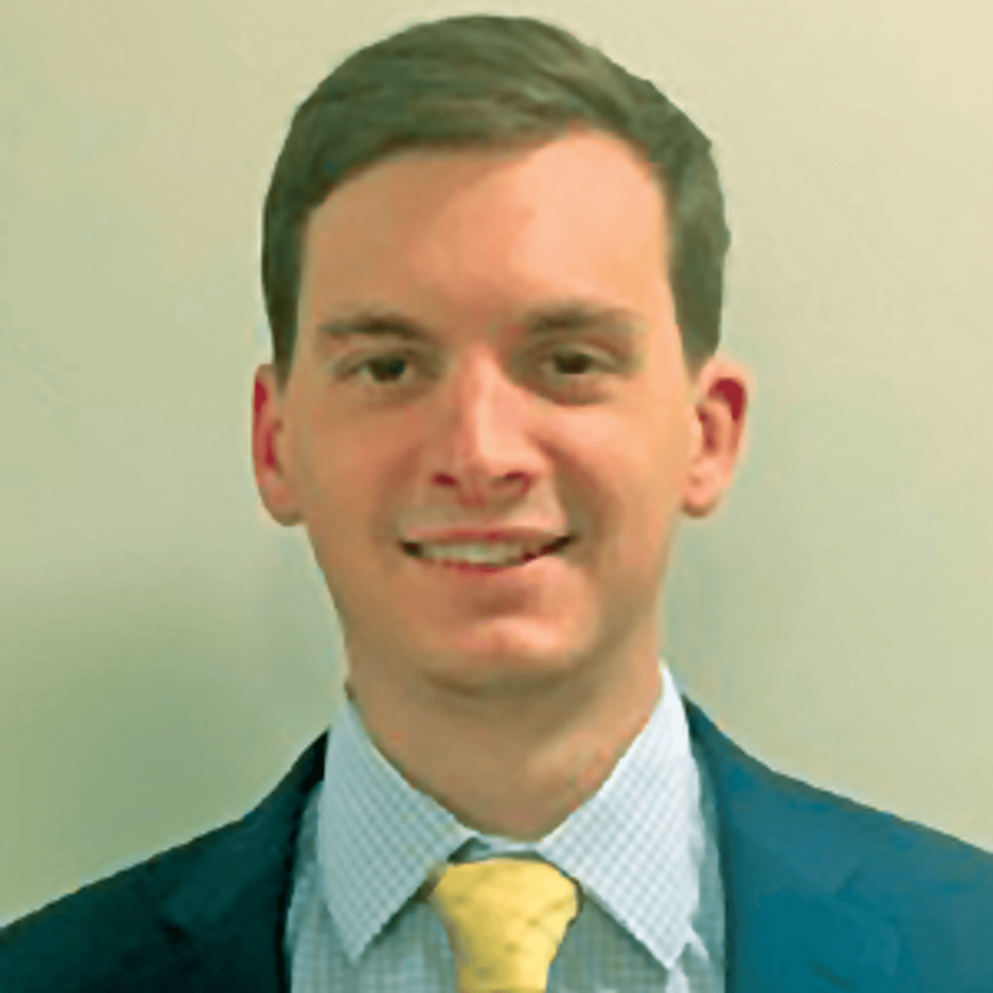 a man wearing a suit and tie smiling at the camera