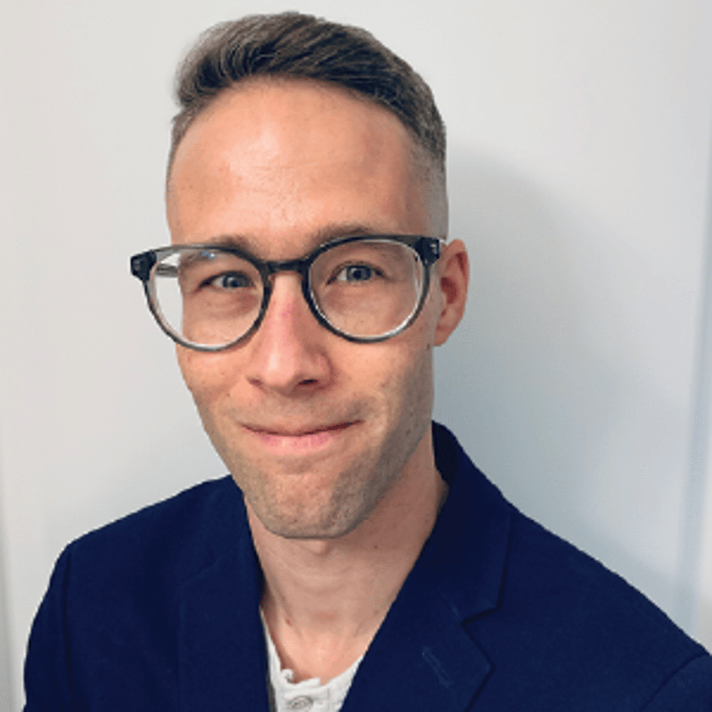 a man wearing glasses and looking at the camera