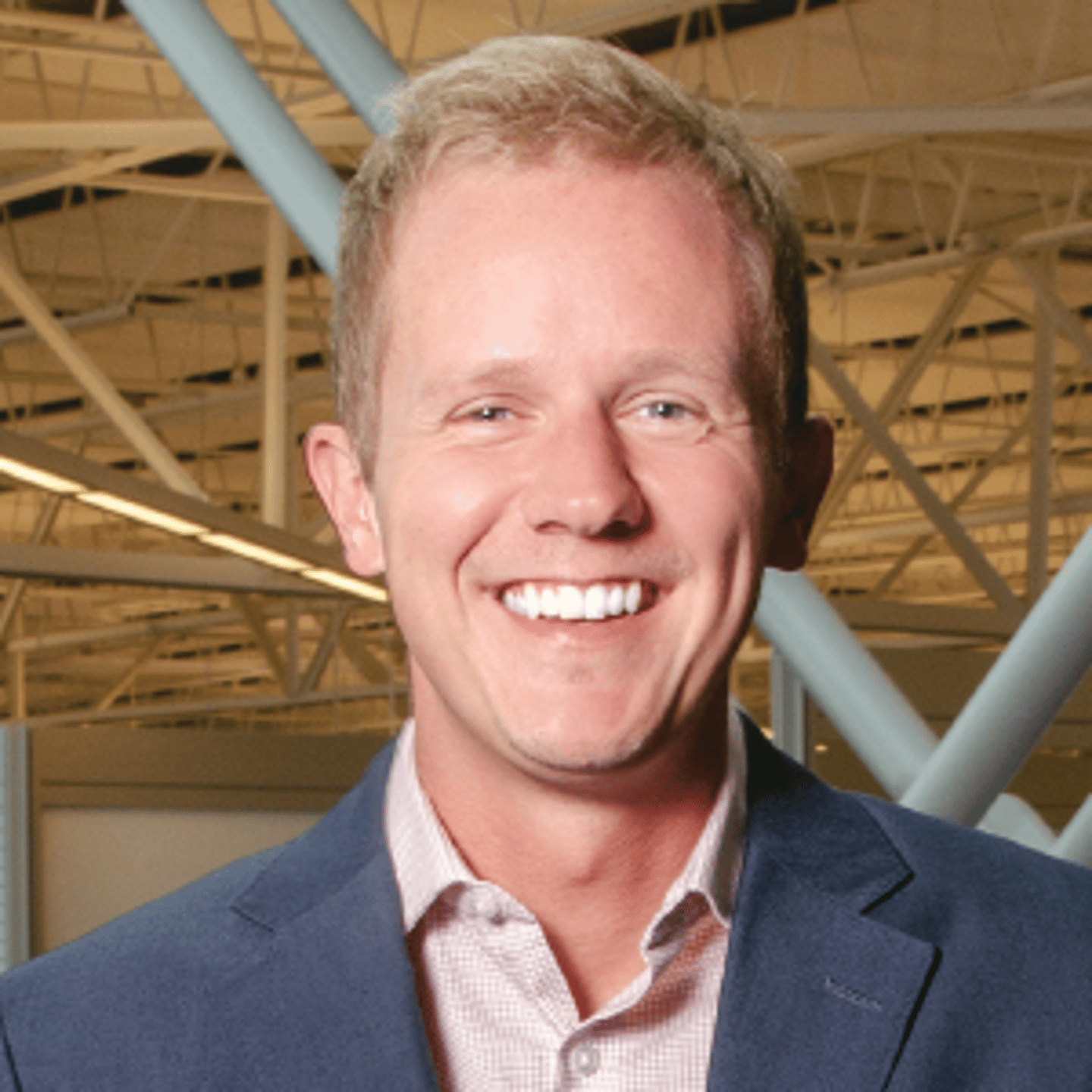 a man wearing a suit and tie smiling at the camera