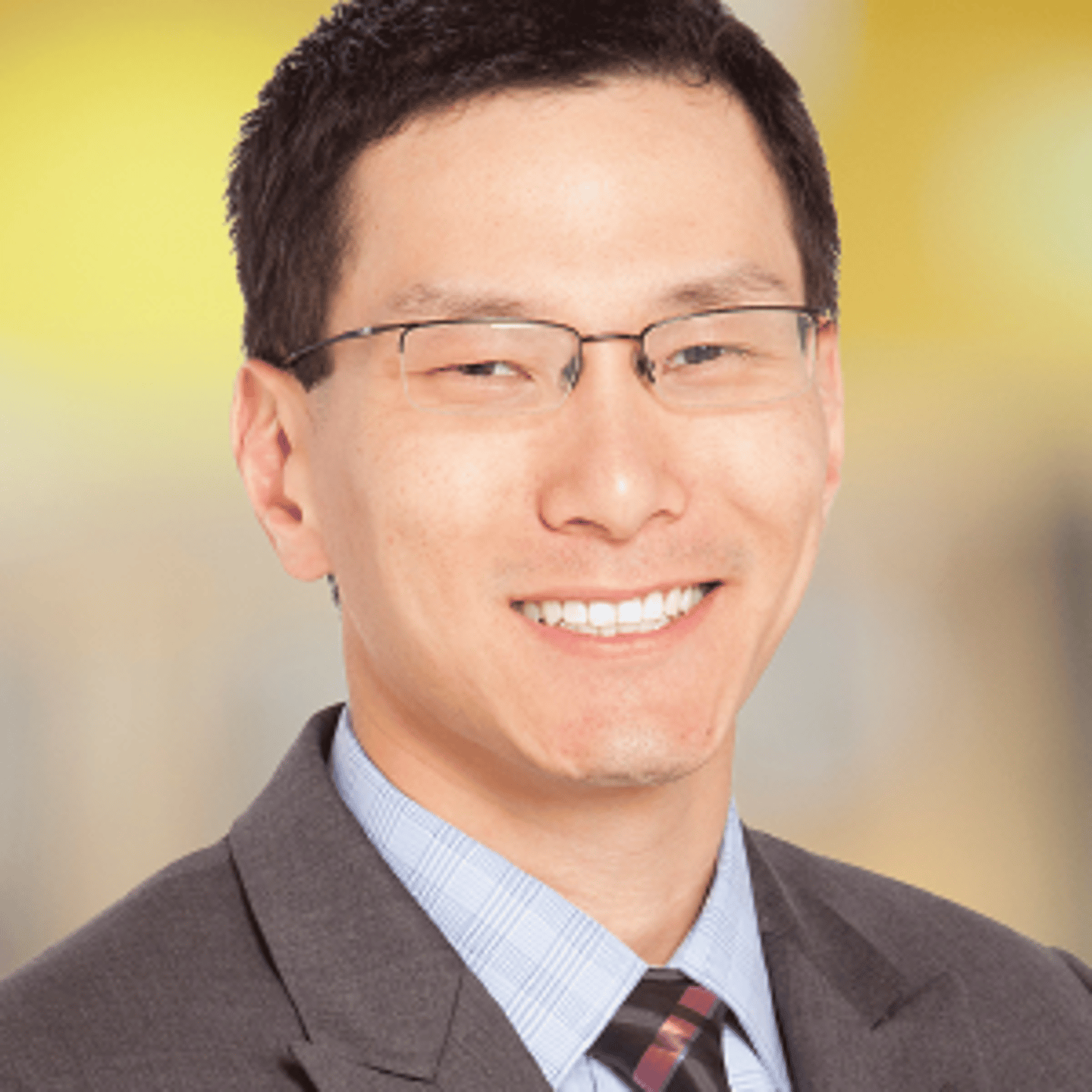 a man wearing a suit and tie smiling at the camera