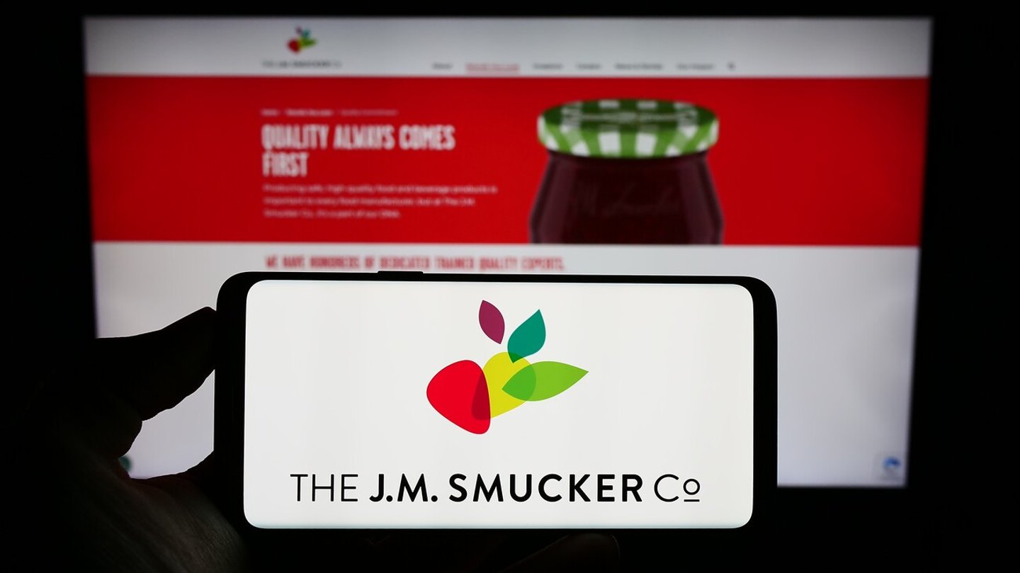 Stuttgart, Germany - 08-08-2023: Person holding smartphone with logo of US food business The J.M. Smucker Company on screen in front of website. Focus on phone display. Unmodified photo.; Shutterstock ID 2349221637